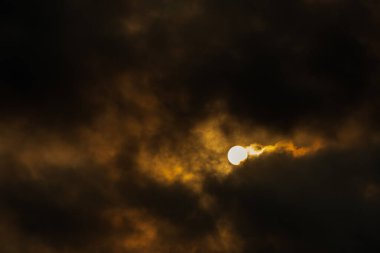 Güneş, kara bulutların arkasında saklanıyor. Sıcak ve parlak güneş ışınlarını serbest bırakmaya çalışıyor. Dünyada yaşayan her şeye enerji vermek için.