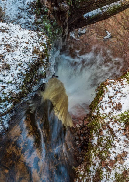 森林中的小河瀑布 地面上覆盖着一层薄薄的雪 初春的时候 流水散发着光芒 — 图库照片