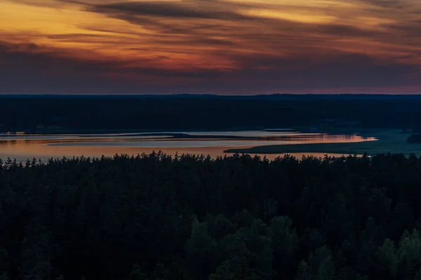 オレンジ色に塗られた日没後湖の森に囲まれ — ストック写真