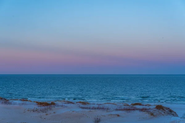 早朝の穏やかな海日の出前の朝のピンク色の色調の砂と空 ストック画像