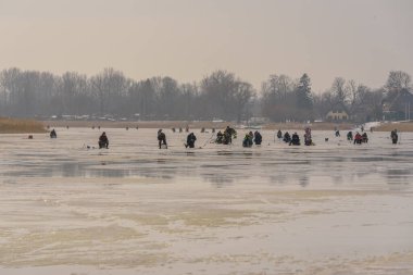 Donmuş nehir, bükük ve buzlu balıkçılar daha fazla balık yakalamak için donmuş bir nehir boyunca ilerliyorlar.