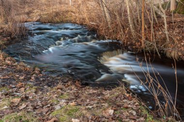 Birkaç aşamalı şelale ve düşen yapraklar kahverengidir ama kışın ardından bahar mevsiminde su akar.