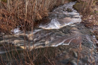 Birkaç aşamalı şelale ve düşen yapraklar kahverengidir ama kışın ardından bahar mevsiminde su akar.