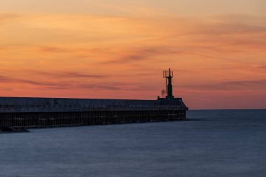 Baltık denizinde gün batımı nehrin denizle buluştuğu rıhtıma bakan ve sakin suların aktığı bir huzur hissi yaratıyor.