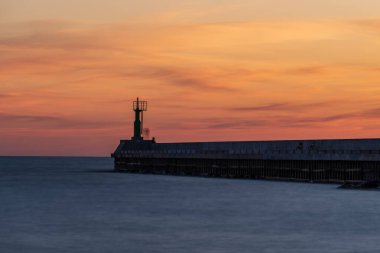 Baltık denizinde gün batımı nehrin denizle buluştuğu rıhtıma bakan ve sakin suların aktığı bir huzur hissi yaratıyor.