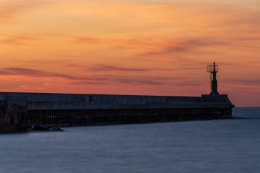 Baltık denizinde gün batımı nehrin denizle buluştuğu rıhtıma bakan ve sakin suların aktığı bir huzur hissi yaratıyor.