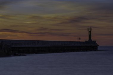 Baltık denizinde gün batımı nehrin denizle buluştuğu rıhtıma bakan ve sakin suların aktığı bir huzur hissi yaratıyor.
