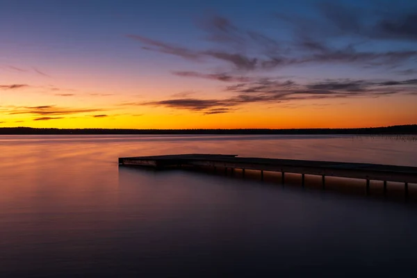 Pôr Sol Margem Lago Com Uma Passarela Uma Superfície Água — Fotografia de Stock