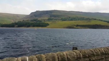 Rüzgar sörfçüleriyle Dovestone Reservoir 'un yavaş çekim görüntüsü.