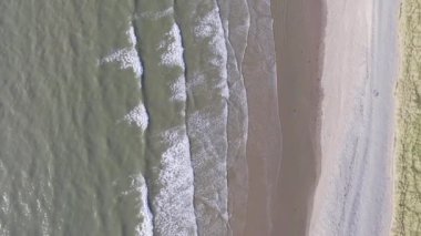 Fairbourne sahilindeki dalgaların aşağı doğru havadan çekilmiş görüntüsü..