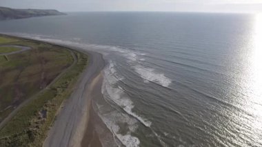 Fairbourne 'da denize ve taşlı plaja bakan yüksek bir hava görüntüsü..