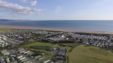Bu hava görüntüleri güneşli bir günde Talybont 'ta denize doğru uçuyor. Denizin yanında birçok kervan görebilirsiniz..