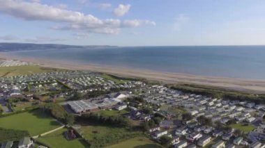 Bu hava görüntüleri güneşli bir günde Talybont 'ta denize doğru uçuyor. Denizin yanında birçok kervan görebilirsiniz..