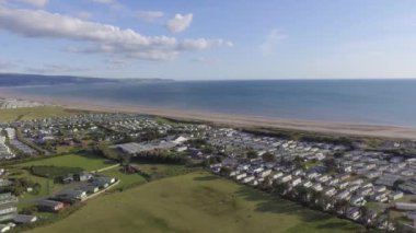 Bu hava görüntüleri güneşli bir günde Talybont 'ta denize doğru uçuyor. Denizin yanında birçok kervan görebilirsiniz..