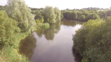 İngiltere yaz gününde büyük bir göletin üzerinde uçan hava manzarası..