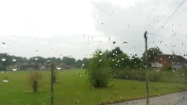 Camda yağmur damlaları ve dışarıda giden arabalarla pencereyi kapat..