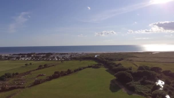 この航空写真は 北ウェールズのタリボントで撮影されました 晴れた日に海と水平線に焦点を当てた上昇ショットです 撮影されたキャラバンもあります — ストック動画