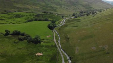 Barbon Beck Vadisi, Carnforth, Lancashire, İngiltere 'ye bakan yüksek irtifalı bir hava görüntüsü. Bu çarpıcı kırsal kesimde bir köy şeridi boyunca akan bir dere var..
