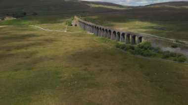 Bu Cumbria, İngiltere 'deki Ribblehead Viaduct' un statik görüntüsü. Hava biraz bulutla güneşliydi ve yeşil kırsal bölgeleri en iyi şekilde değerlendirmek için yaz mevsiminde kaydedildi..