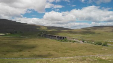 Bu Cumbria, İngiltere 'deki Ribblehead Viaduct' un statik görüntüsü. Hava biraz bulutla güneşliydi ve yeşil kırsal bölgeleri en iyi şekilde değerlendirmek için yaz mevsiminde kaydedildi..