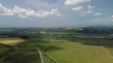 Caton Moor 'da yükselen bir hava görüntüsü, Grange-over-Sands' e bakıyor. Lancaster. Güneşli ama bulutlu bir yaz gününde göz kamaştırıcı yeşil kırları görebilirsiniz..