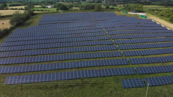 夏の間 英国の緑の田舎の太陽電池パネルの分野をゆっくりと飛んでいます — ストック動画