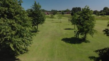 Manchester, İngiltere 'de bir yaz gününde yeşil bir alanda ağaçların arasından bir geri çekilme.