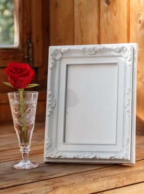Fotoğraf çerçevesi ve bir kırmızı gül