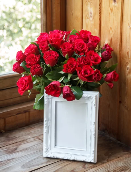 Marco blanco y racimo de rosas rojas — Foto de Stock
