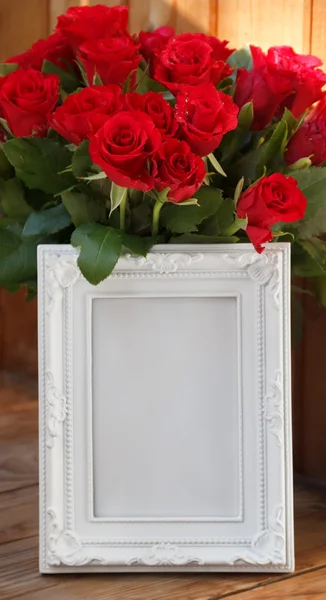 Beyaz bir çerçeve ve kırmızı gül demet