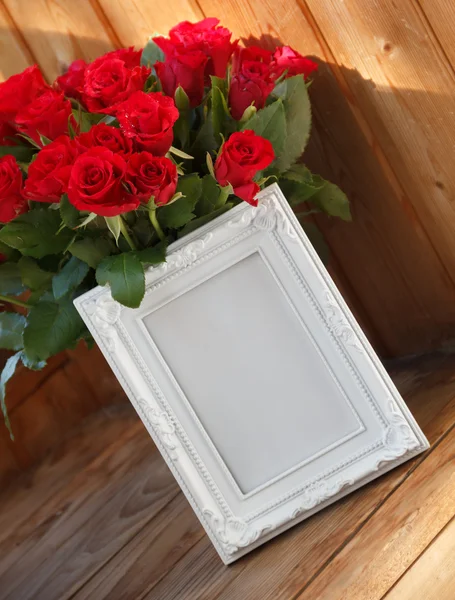 Beyaz bir çerçeve ve kırmızı gül demet
