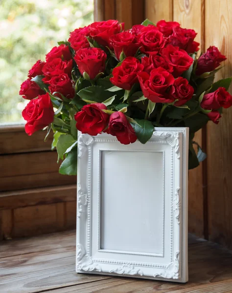 白いフレームと赤いバラの花束 ストックフォト