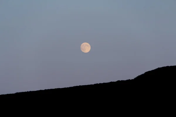 A lua grande brilha sobre a montanha. Boa noite. — Fotografia de Stock