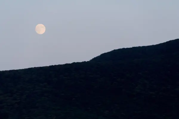 A lua grande brilha sobre a montanha. Boa noite. — Fotografia de Stock