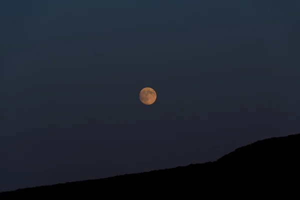 Big moon shines over the mountain. Night