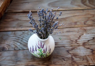 Penceresinde bir vazoda lavanta çiçekleri vardır