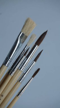 Gri arkaplanda boya fırçaları, yakın plan.