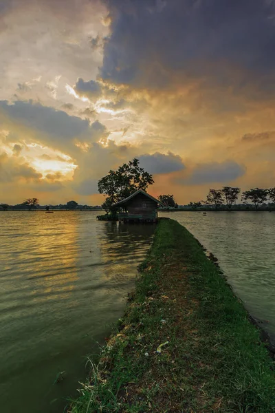 Cikoneng-Bandung şehrinde gün batımında kır evi ve göl manzarası. Seçici odaklanma, uzun pozlama.