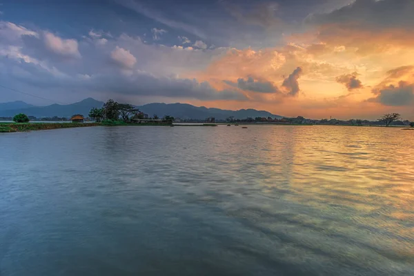 Cikoneng-Bandung şehrinde gün batımında kır evi ve göl manzarası. 