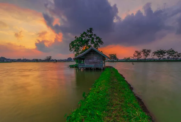 Cikoneng-Bandung şehrinde gün batımında kır evi ve göl manzarası. 