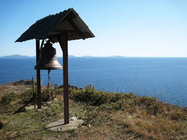 Bell on a cliff in the sea — стоковое фото