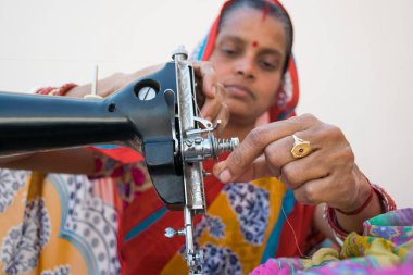 Dikiş makinesi kullanan sıradan bir kadının portresi.