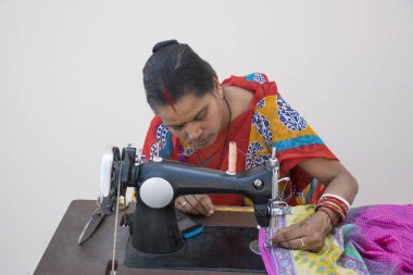 Hintli kırsal kadın dikiş makinesi kullanıyor