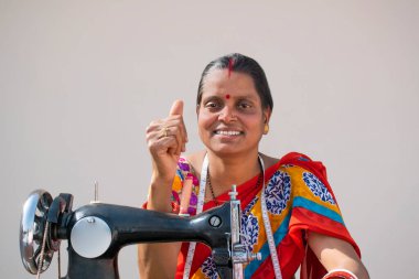 Kırsal Kadın İşçi Terzisi Başparmaklarını Gösteriyor