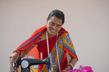 Hindistan 'ın kırsal kesimlerinde Hintli bir kadın kumaş dikiyor.