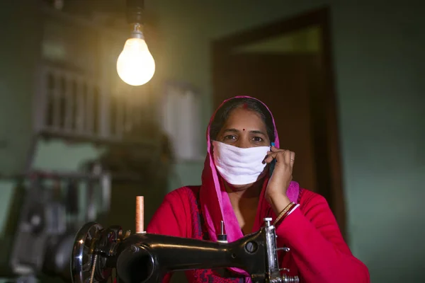 Maske takan ve cep telefonuyla konuşan sıradan bir kadının portresi.