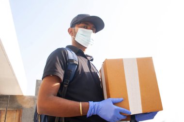 Arkaplanda Karton Kutu Taşıyan Genç Teslimatçının Portresi