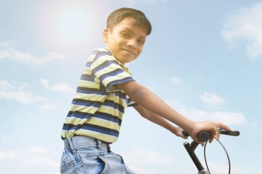Bisiklette oturan kendinden emin bir çocuğun portresi