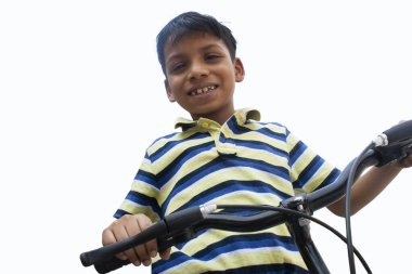 Bisiklette oturan kendinden emin bir çocuğun portresi