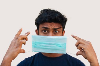 Genç Çocuk, Corona virüsünden korunmak için tıbbi maske kullanıyor.